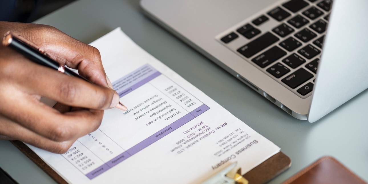 Person writing on a invoice