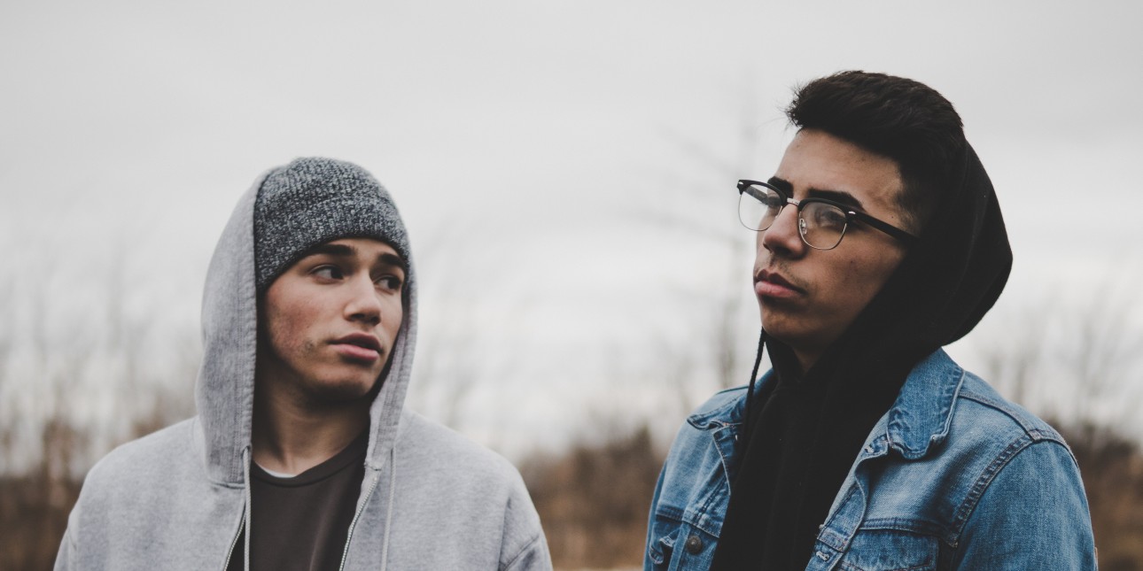 Two men standing in a field of grass