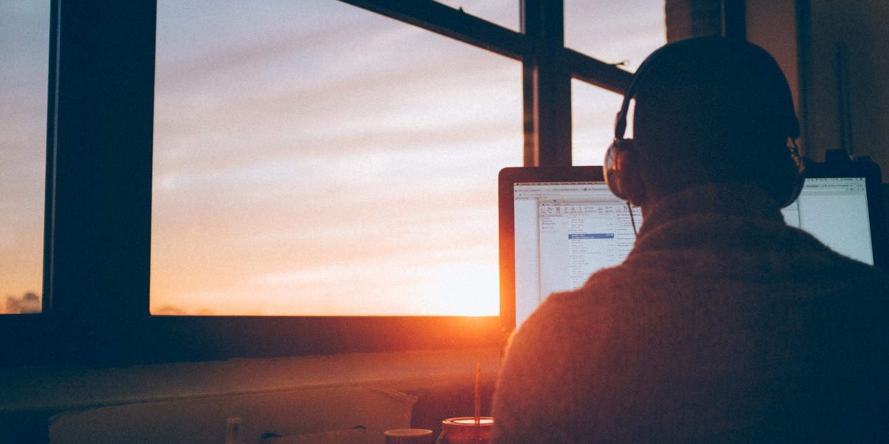 man working at a computer at sunset