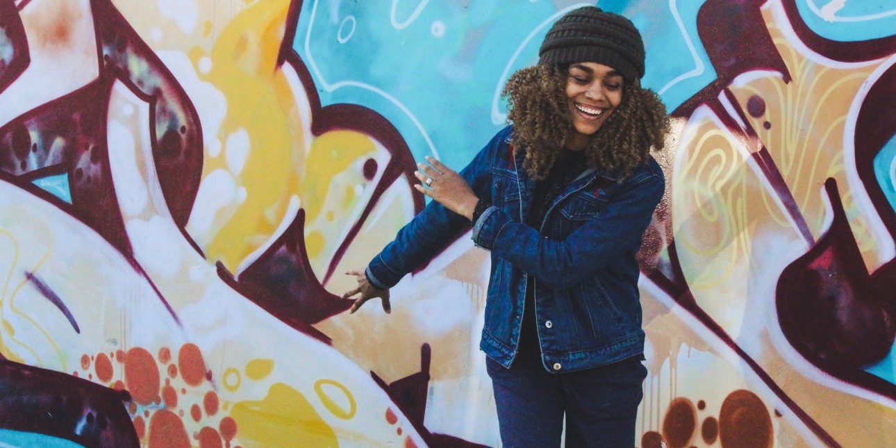 Woman dancing near a mural