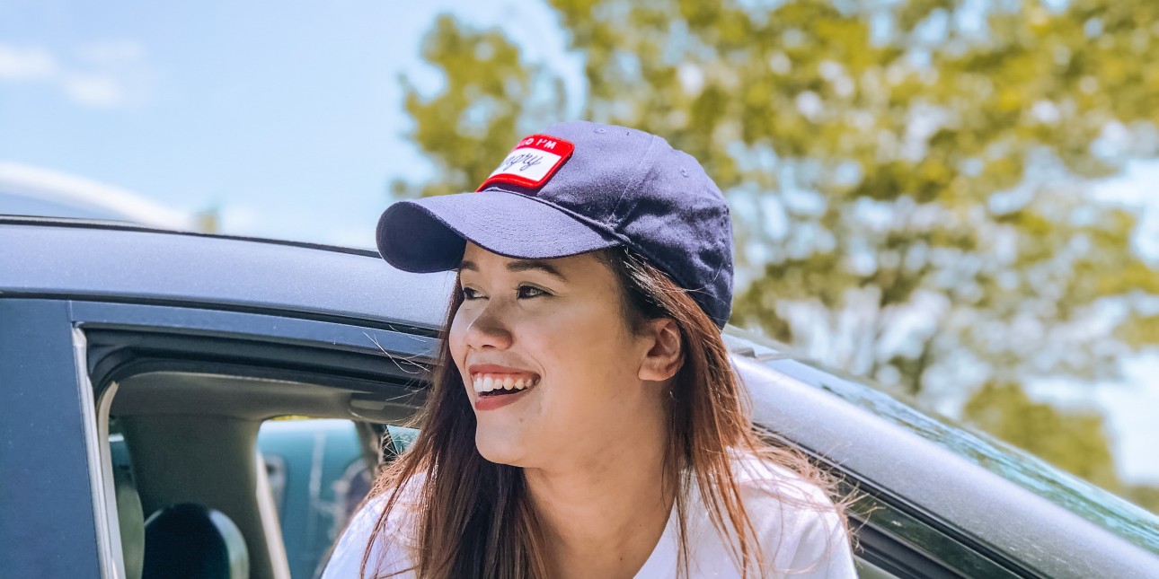 Happy young woman in car in city