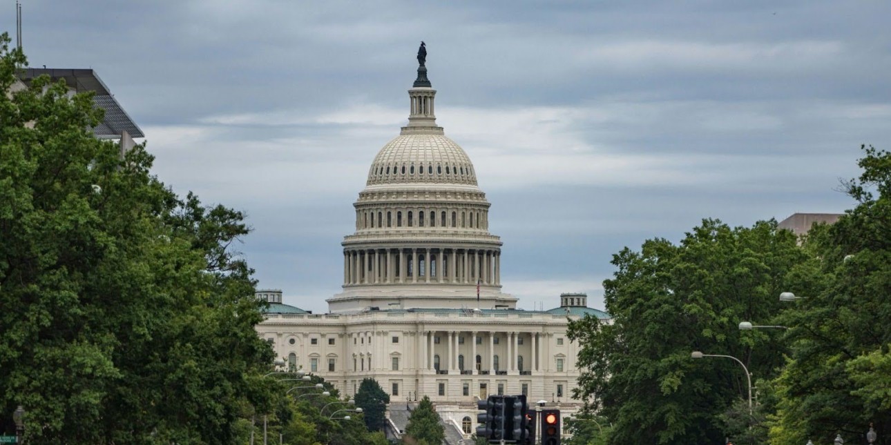 A view down a busy Washington, DC street toward the Capitol