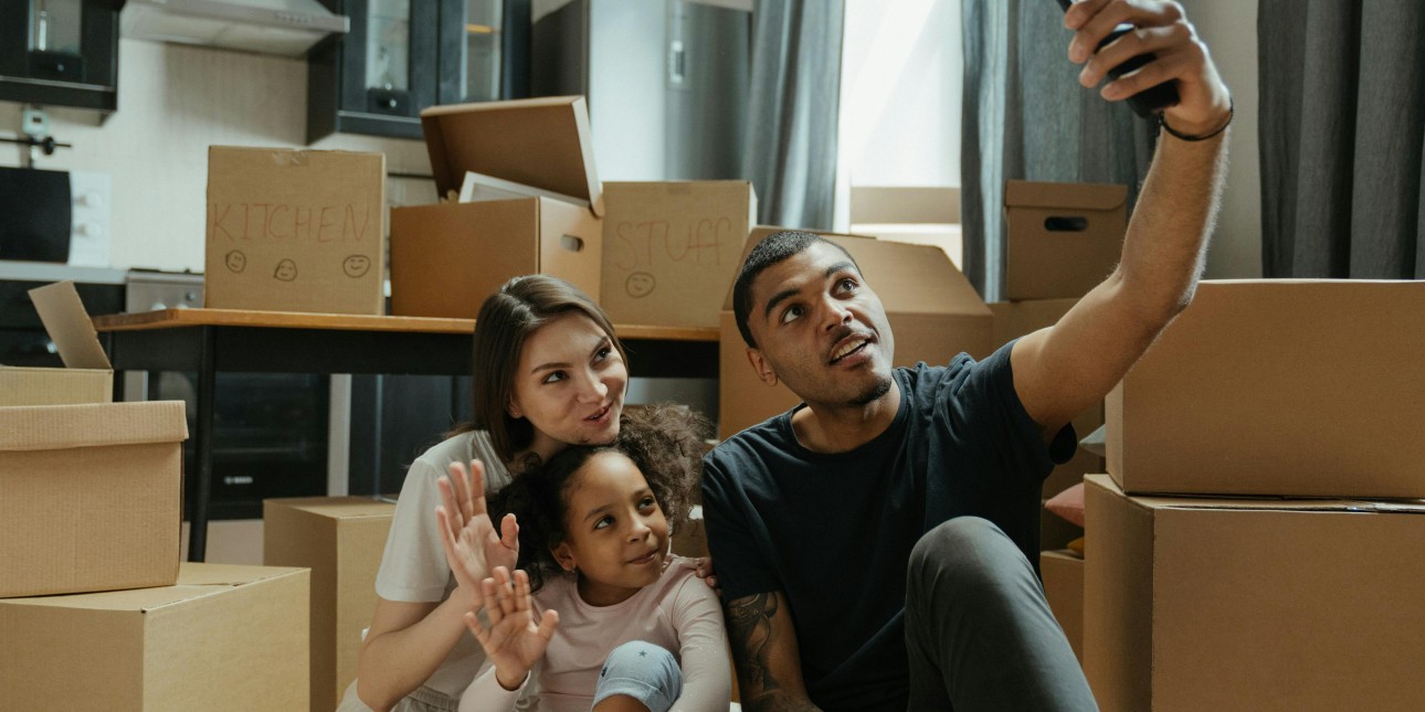 A young family poses for a groupie photo in the kitchen of their new home.