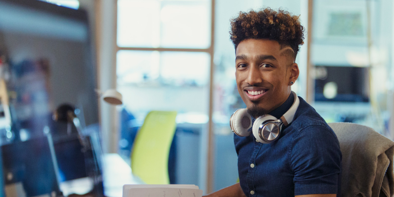 a person sitting at a desk smiling