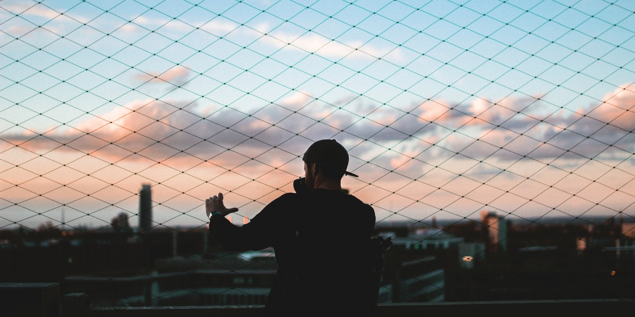 Man standing by a fence