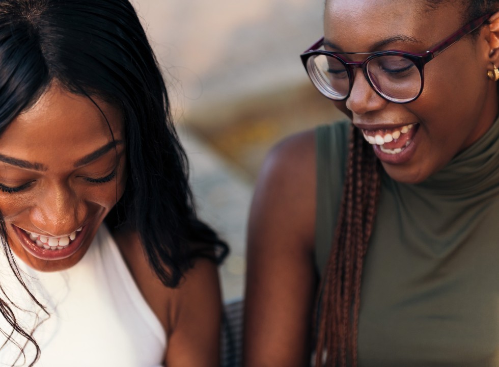 Two Black women laughing together
