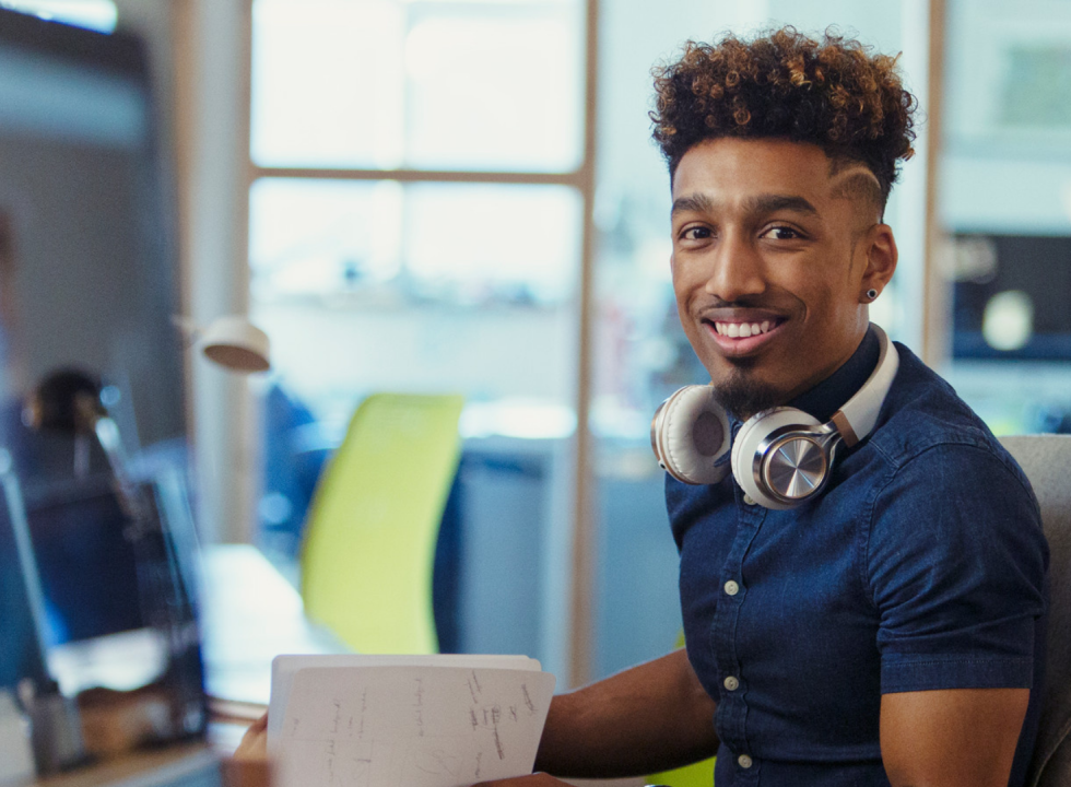 a person sitting at a desk smiling