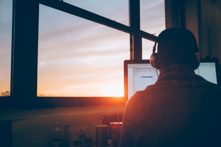 man working at a computer at sunset