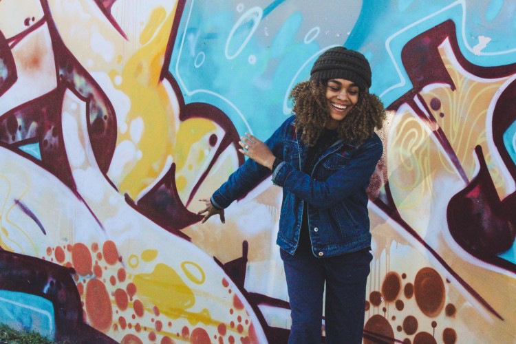 Woman dancing near a mural