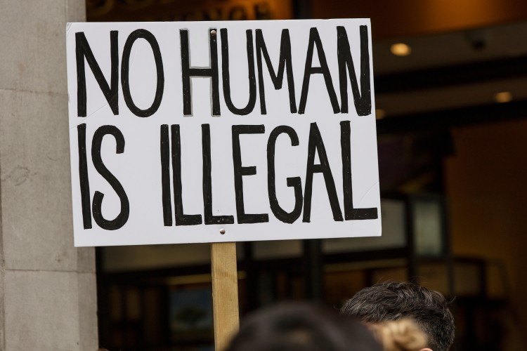 A protest sign reading, "NO HUMAN IS ILLEGAL"