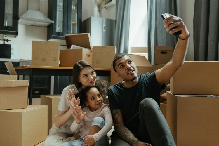 A young family poses for a groupie photo in the kitchen of their new home.