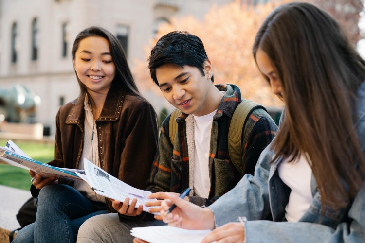 Teen young adults sitting outdoors together