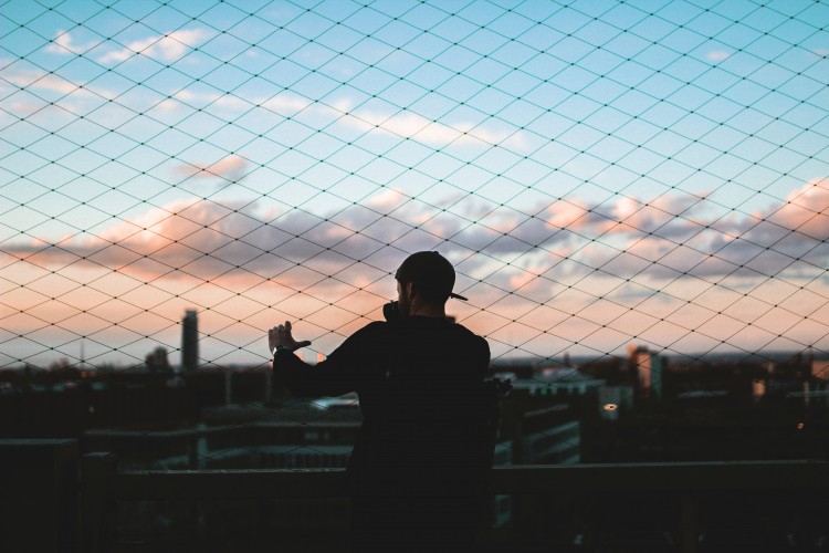 Man standing by a fence